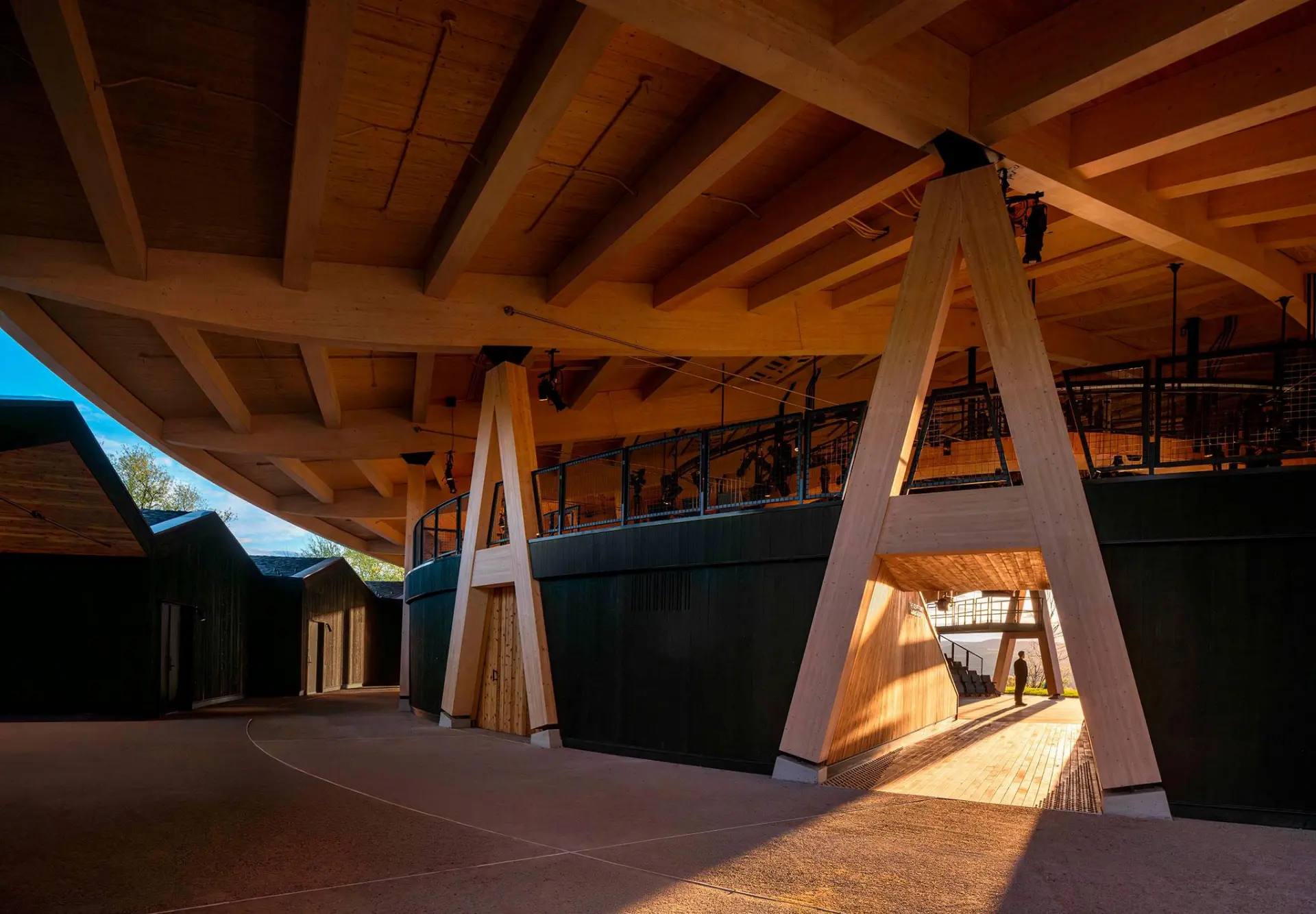 Beneath the shell, exposed A-frame columns and warm timber soffits turn circulation into an architectural experience. Photo: Jason O'Rear / Studio Gang.