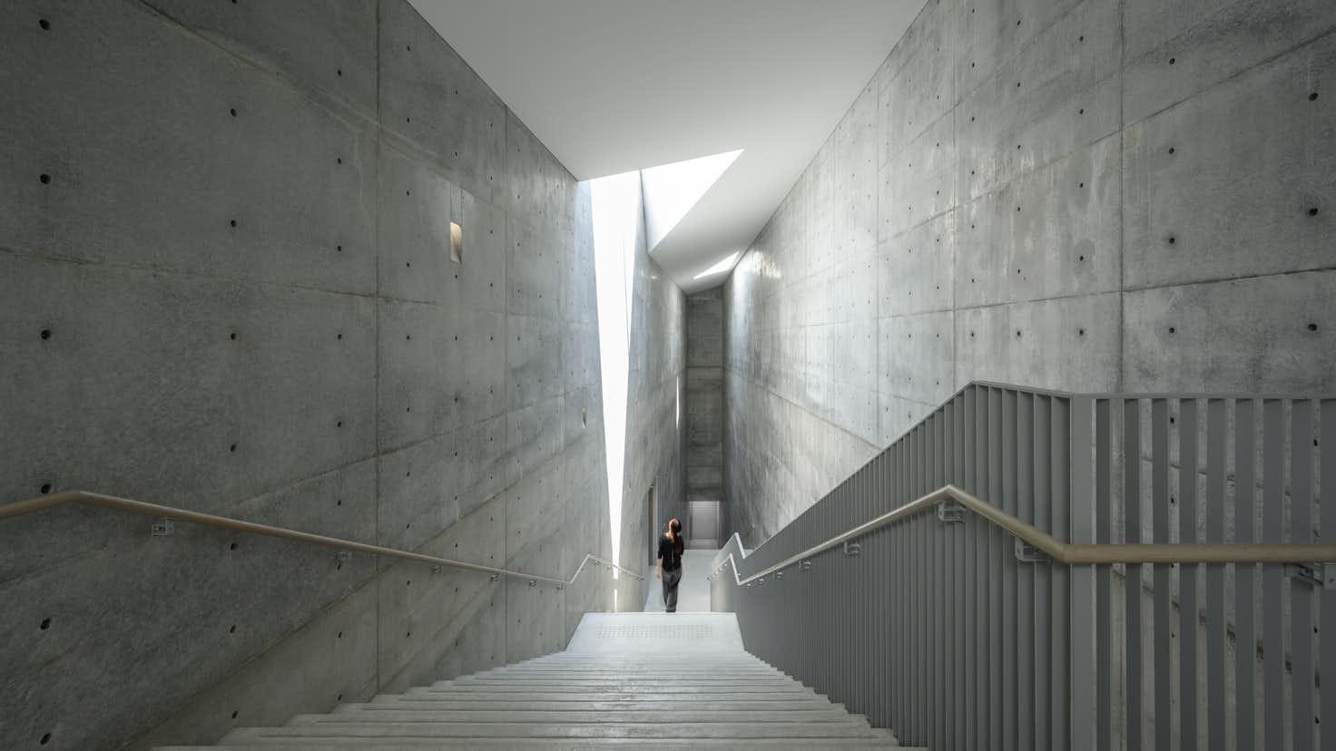 The central staircase descends through two underground levels, lit from a skylight above — concrete made an instrument of atmosphere. Photo: Benesse Art Site Naoshima.
